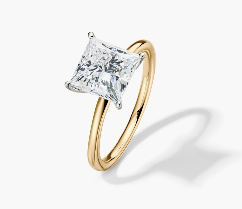 A Helzberg solitaire engagement ring with a yellow  gold band.