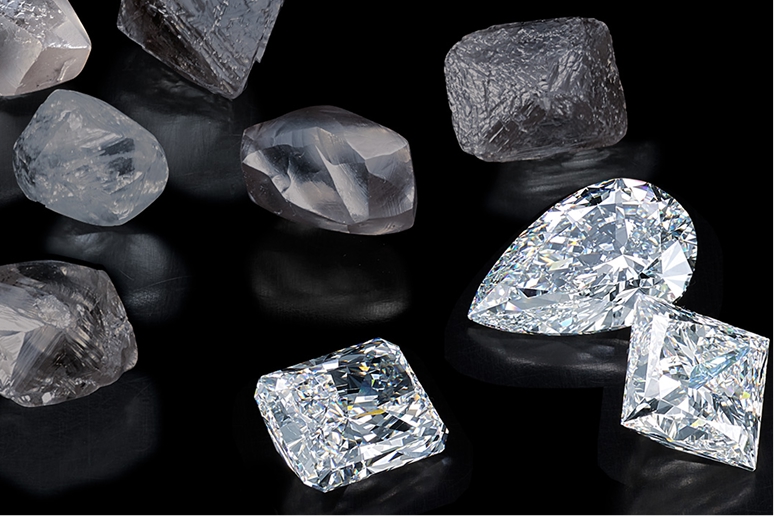 Loose raw and polished diamonds on a black background