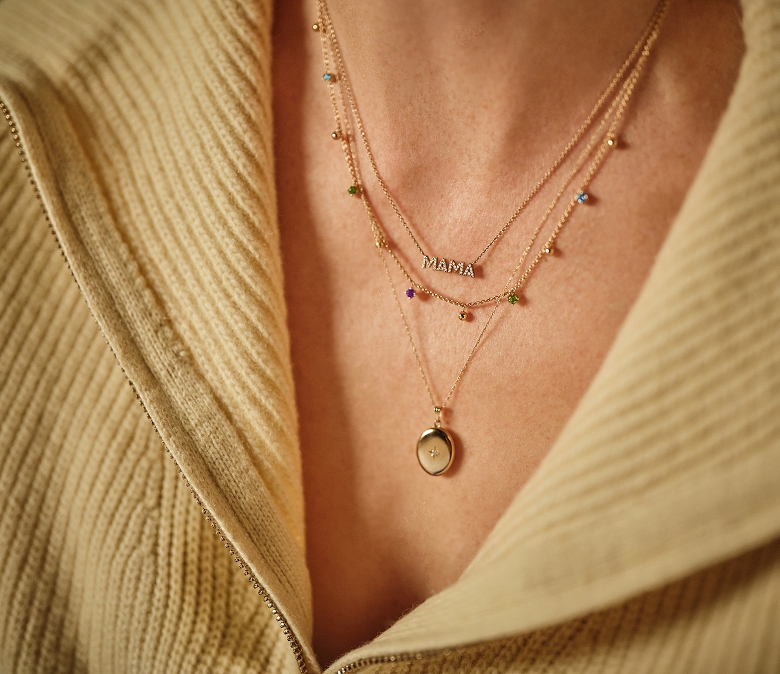 Close p image of a woman's neck showing her necklace stack