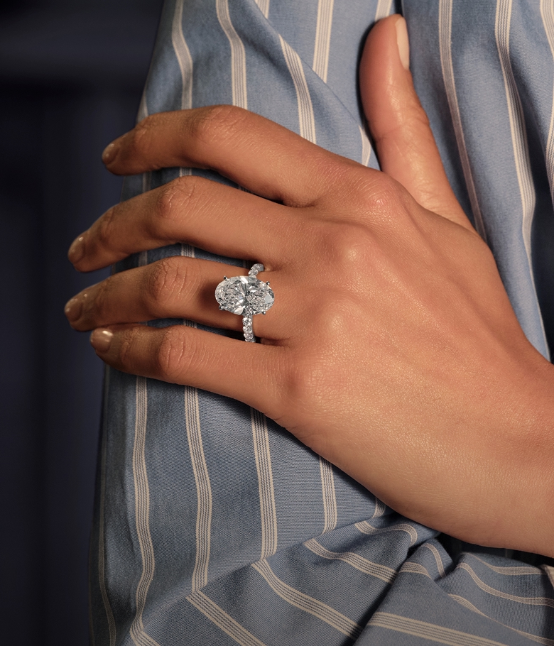 A picture of a female hand resting on her upper arm wearing a lab grown diamond engagement ring. Are lab grown diamonds flawless?
