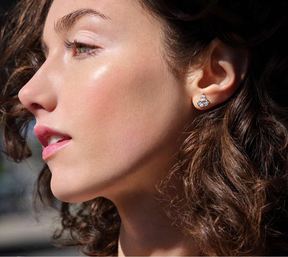 A brunette woman wearing a cluster lab grown diamond stud earring