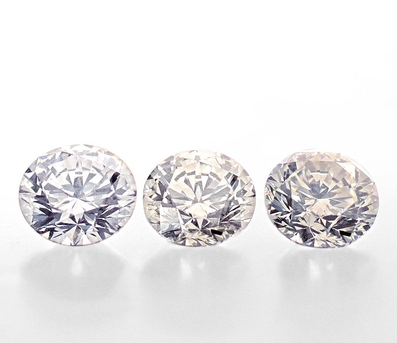 Three round diamonds in varying color grades
