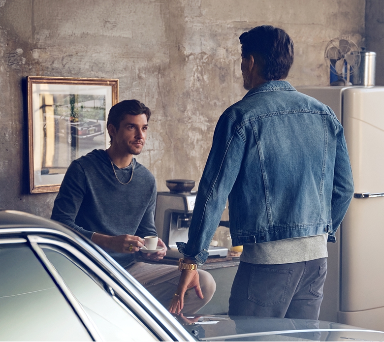 A father and son chatting in a garage while fixing a car and sipping on some espresso. Shop the fathers day gift guide.