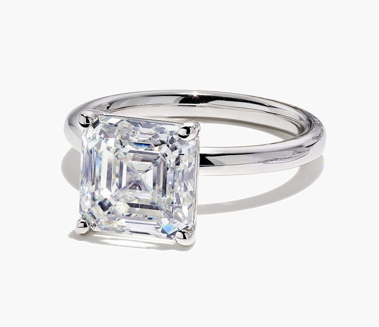 White gold engagement ring featuring an Asscher-cut diamond center stone set on a sleek, polished band.