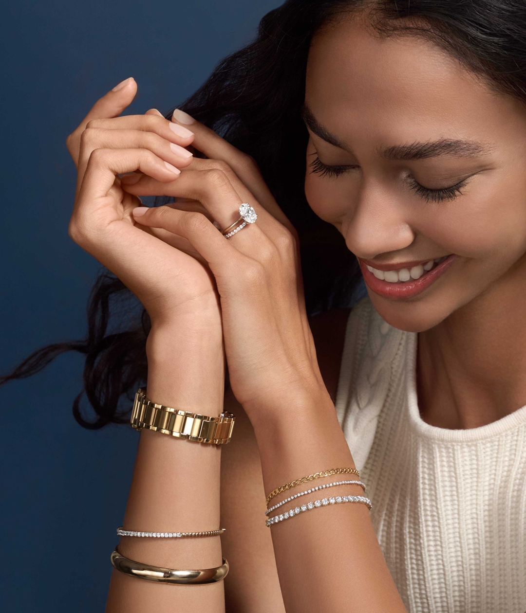 A woman wearing Helzberg engagement rings, bracelets and a watch