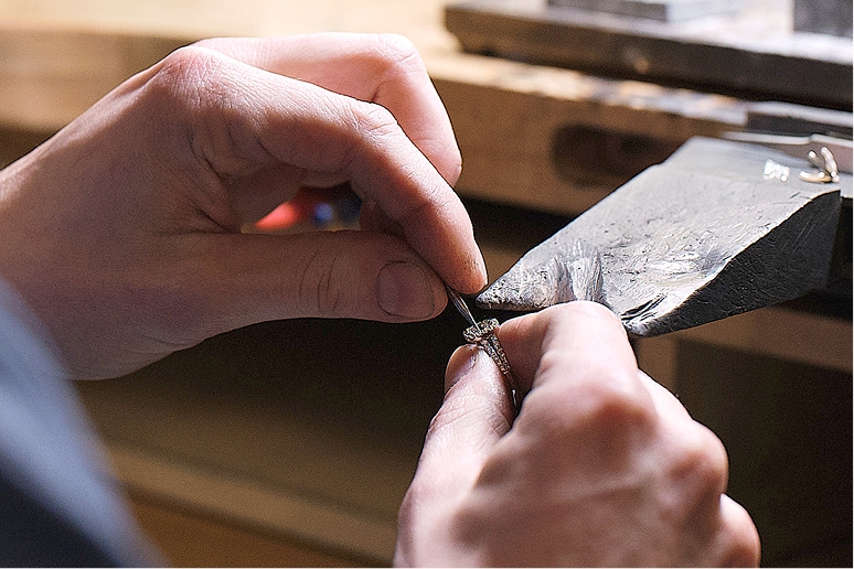 An image of a jeweler making repairs on an engagement ring