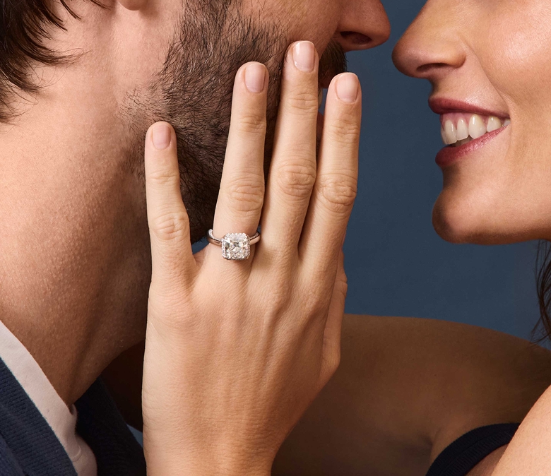 Picture of an round diamond engagement ring on hand. 