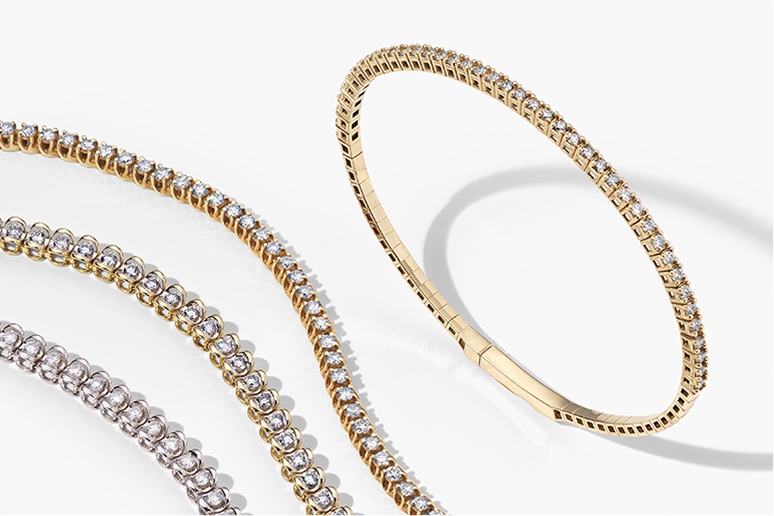 three diamond tennis bracelets and a yellow gold diamond bangle