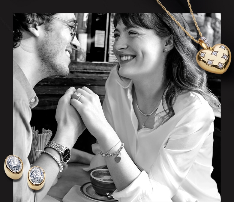A black and white photo of a couple holding hands at a cafe. Over the photo is a yellow gold heart pendant and oval shaped lab grown diamond bezel set stud earrings.