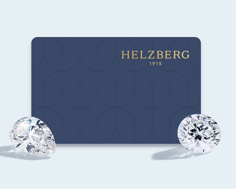 The navy blue Helzberg credit card on a light blue background with two diamonds in front of it.