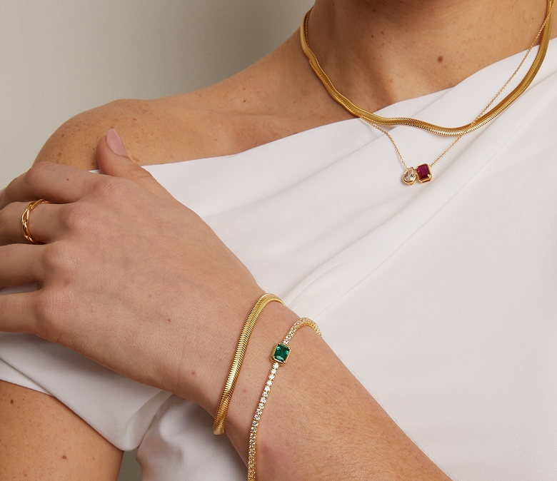 image of a model showing her wrist with bracelets along with a necklace.