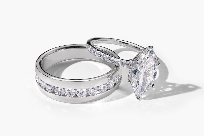 A men's diamond wedding band and a women's lab grown diamond engagement ring