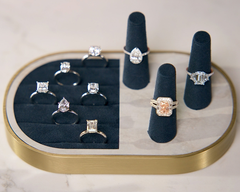 A video of an assortment of engagement rings of all diamond shapes on display.
